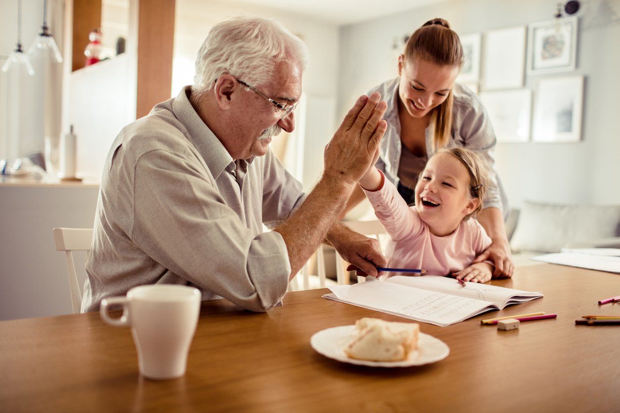 Close up of a grandfather helping out his granddaughter with schoolwork