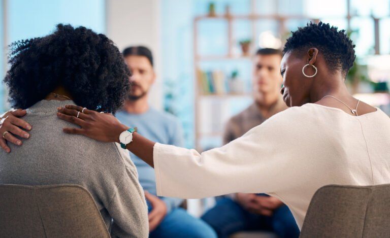 A diverse group of people gathered in a support group, providing emotional support and understanding. The scene depicts empathy, community, and mental health awareness as they share and listen to each other.