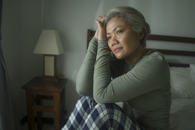 mature lady crisis - indoors lifestyle portrait of middle aged woman with grey hair sad and depressed in bed feeling frustrated and lonely thinking about aging lonely suffering depression