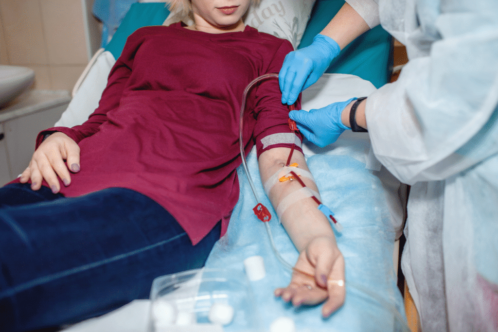 Healthcare worker managing blood tubing during dialysis for a young female patient