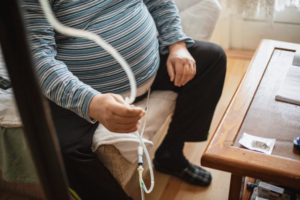 Man performing peritoneal dialysis at home using catheter and tubing