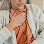 Older woman holding chest, indicating chest pain or heart-related discomfort.
