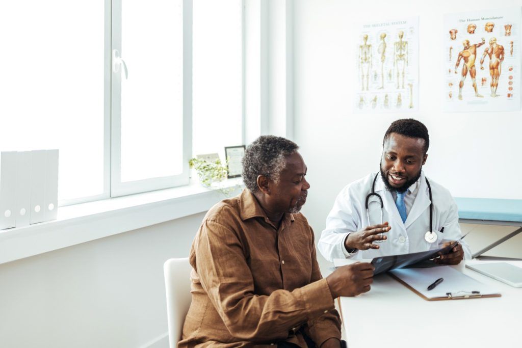 Doctor reviewing an X-ray with a patient in a medical office.