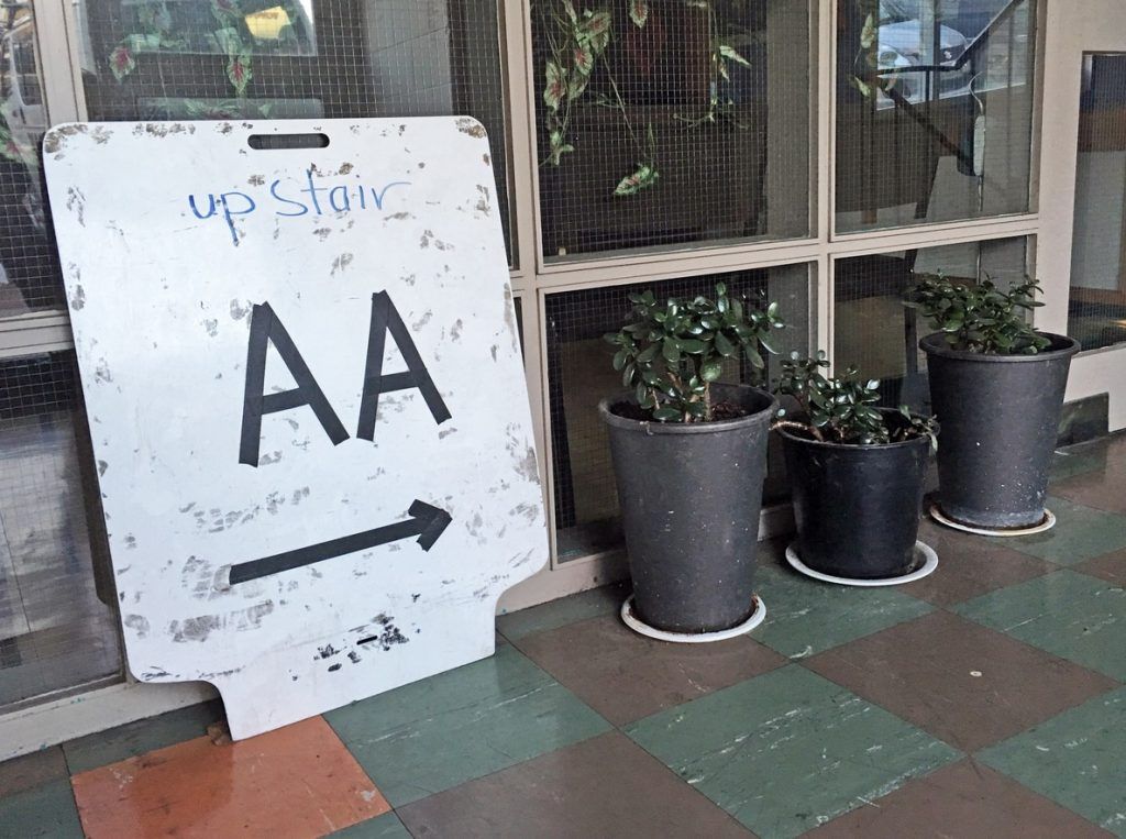 A hallway with a whiteboard sign that says, "upstair AA" with an arrow pointing right.