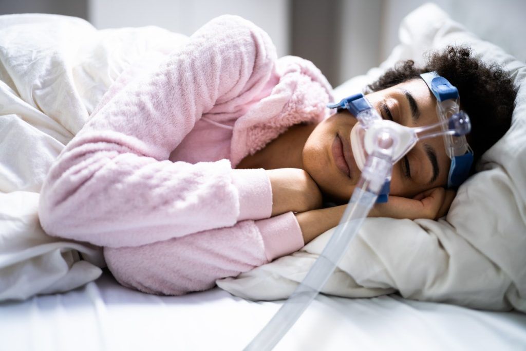 Woman sleeping with cpap machine on.